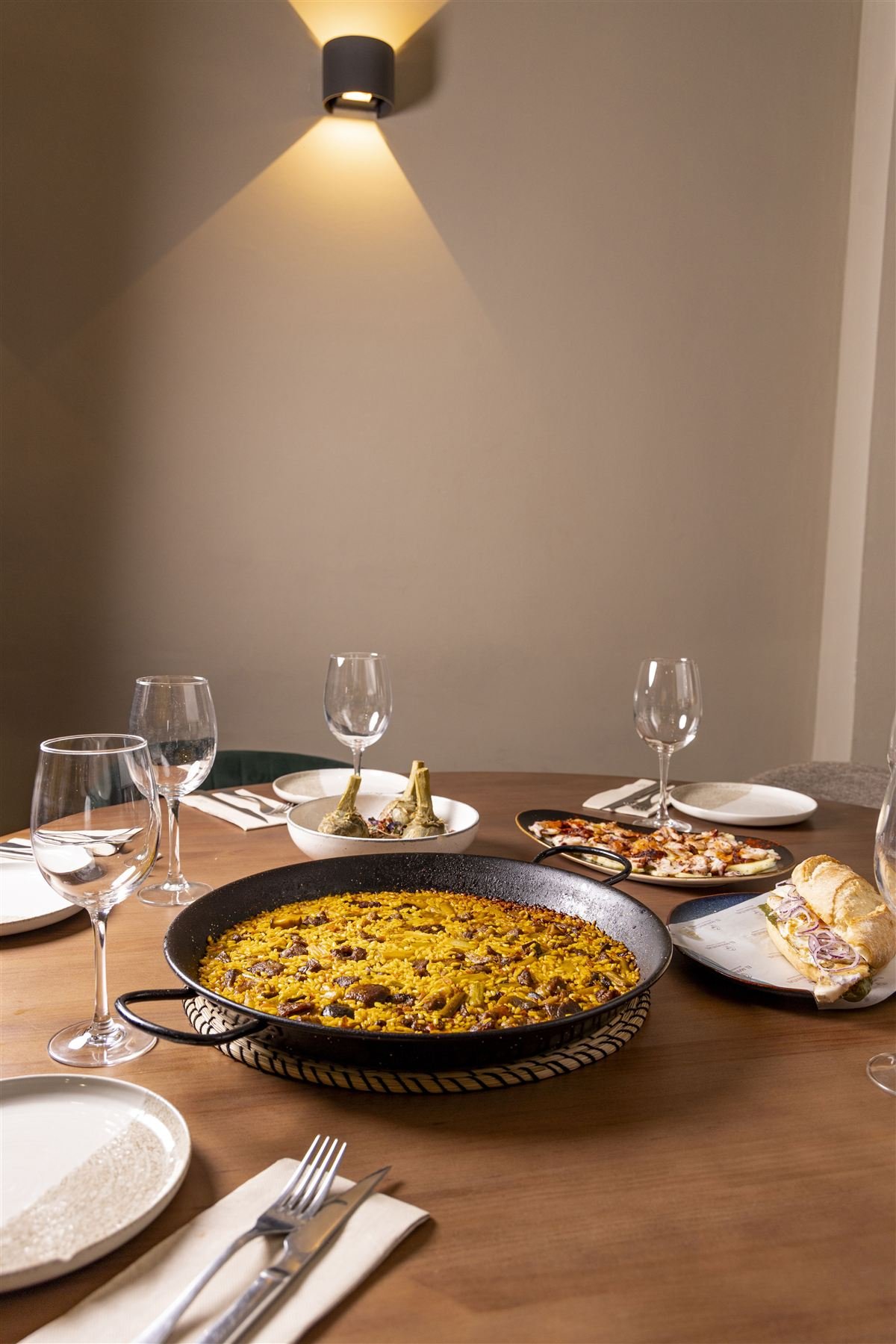 Mesa puesta en El Manantial con paella y entrantes para compartir